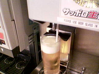 The beer machine tops the glass with froth